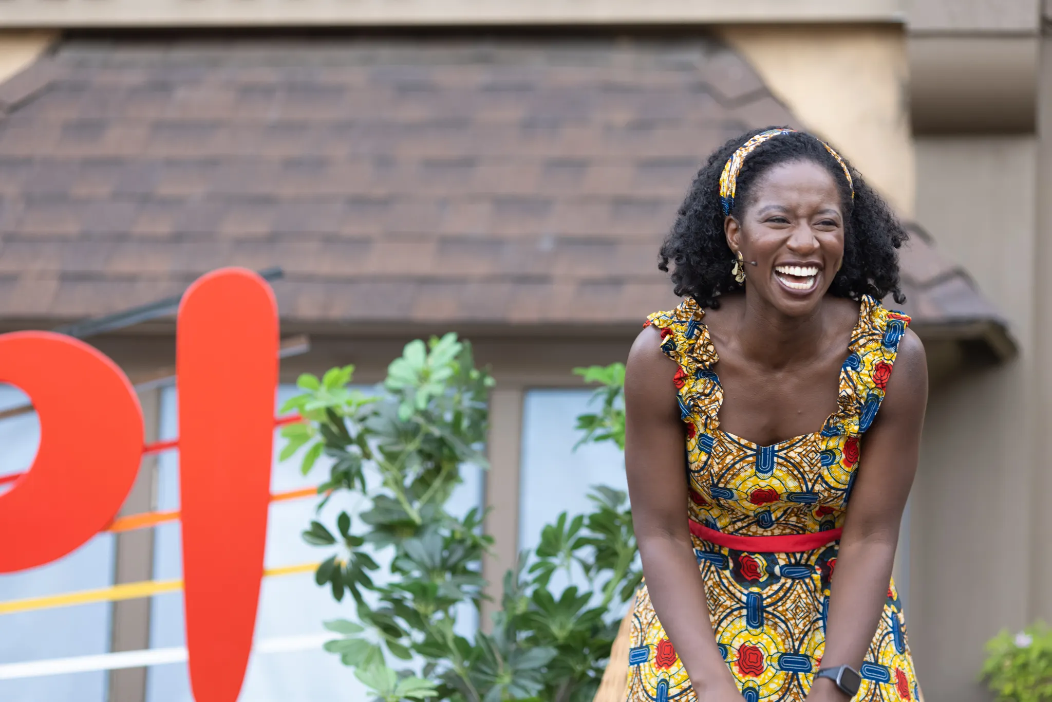 A performer laughing on stage in front of the WORD UP! letters